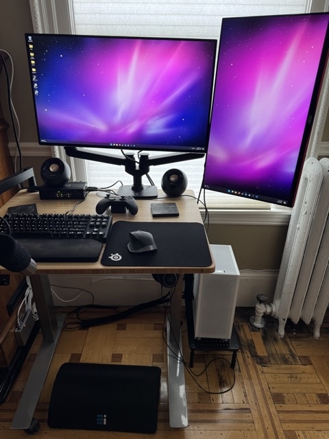 A desk with two monitors and a computer